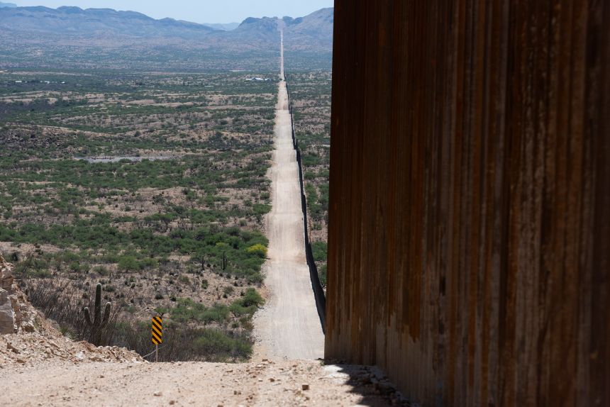 The US-Mexico border fence, which stretches across mountainous terrain near Sasabe, Arizona.